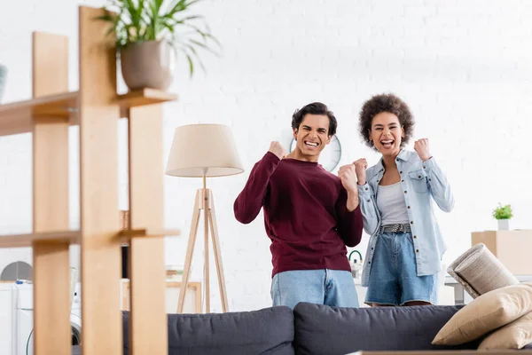 Eccitato coppia interrazziale che celebra la delocalizzazione — Foto stock