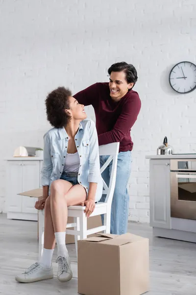 Happy interracial couple looking at each other in new home — Stock Photo