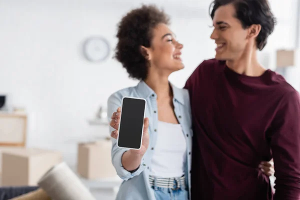 Felice donna africana americana con smartphone in mano con schermo bianco vicino al fidanzato sorridente — Foto stock