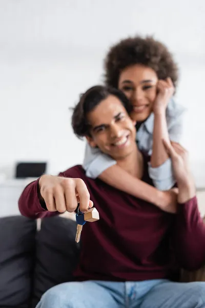 Heureux et flou homme tenant la clé de nouvelle maison près souriant afro-américaine petite amie — Photo de stock