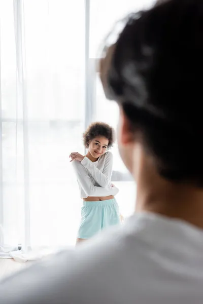 Tímido africano americano mujer mirando borrosa novio - foto de stock