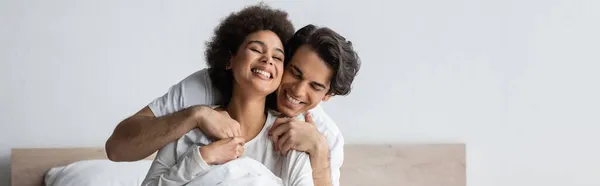 Cheerful man hugging pleased african american woman, banner — Stock Photo