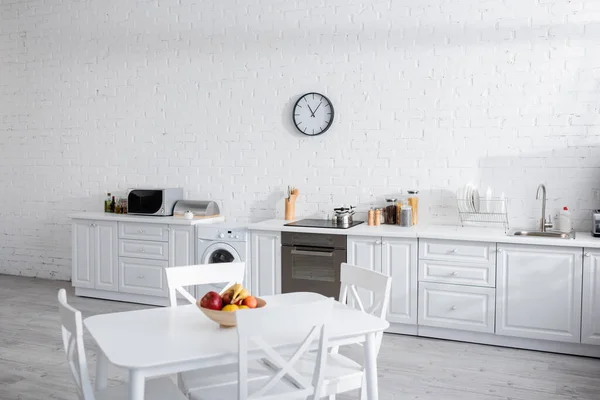 Bol avec des fruits frais sur table à manger blanche dans la cuisine moderne — Photo de stock