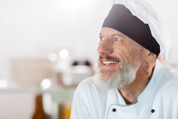 Retrato de chef sorrindo olhando para longe na cozinha — Fotografia de Stock