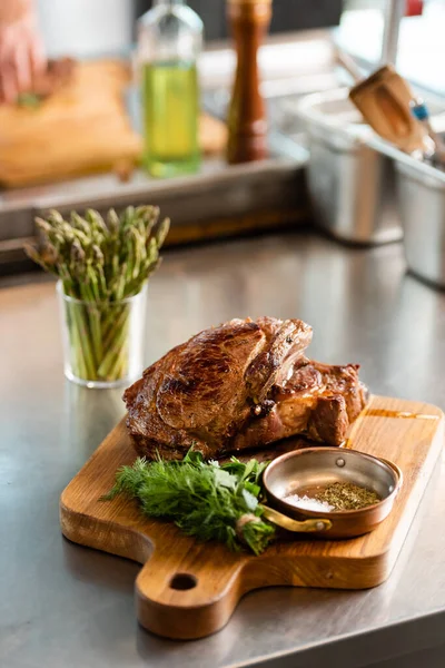 Delicious roasted meat with greens on cutting board — Stock Photo