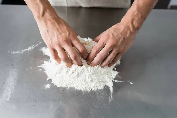 Vue recadrée du chef faisant la pâte sur la table de cuisine — Photo de stock