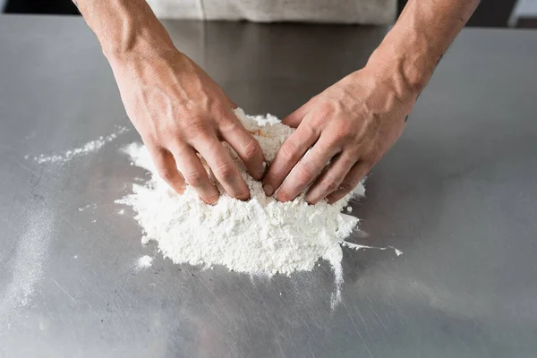 Vista ritagliata dello chef che fa la pasta sul tavolo della cucina — Foto stock