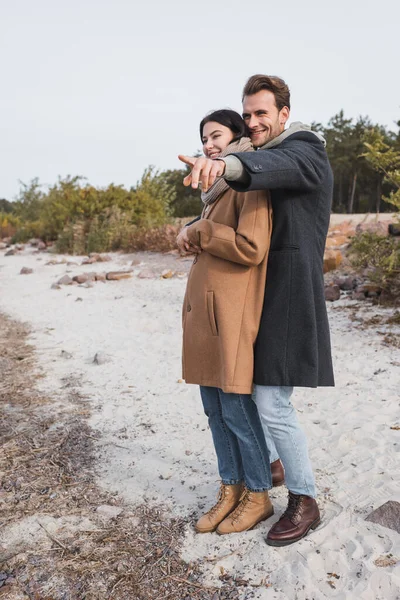 Hombre alegre señalando con el dedo durante el paseo de otoño - foto de stock