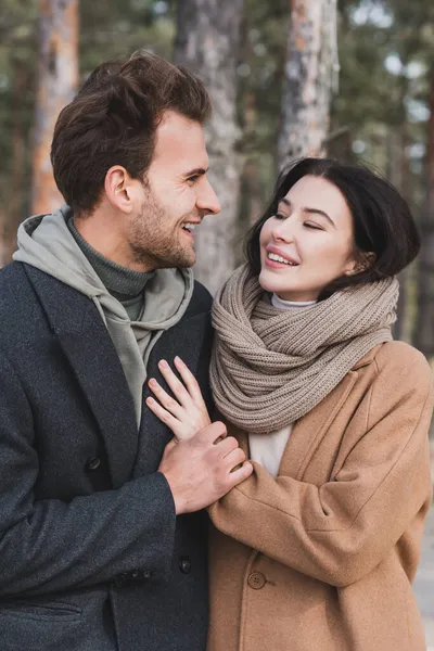 Young man holding hand of happy woman during autumn walk in park — Stock Photo