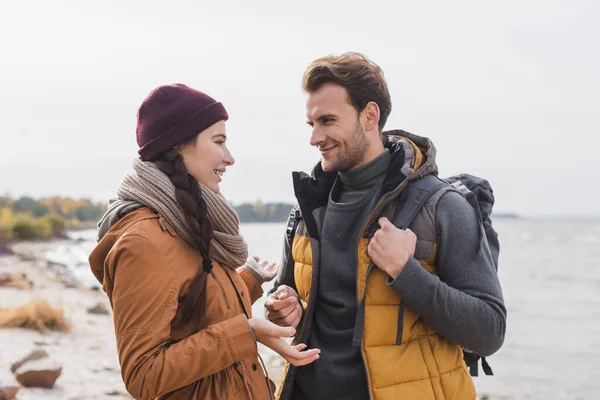 Junge Frau gestikuliert, während sie im Freien mit ihrem lächelnden Freund spricht — Stockfoto