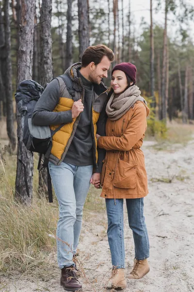 Heureux jeune couple en tenue d'automne randonnée en forêt — Photo de stock