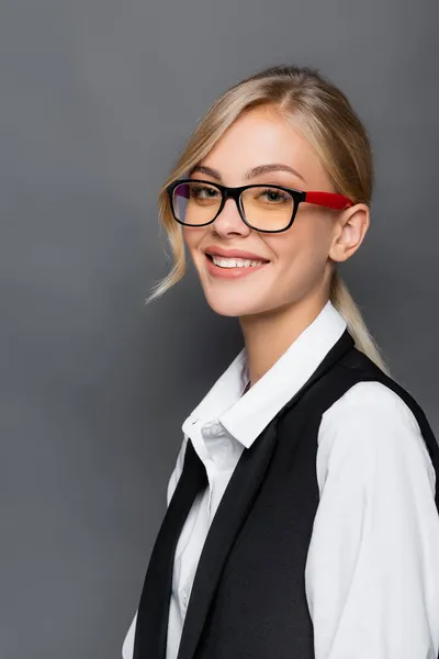 Porträt einer lächelnden blonden Geschäftsfrau, die isoliert auf grau in die Kamera blickt — Stockfoto