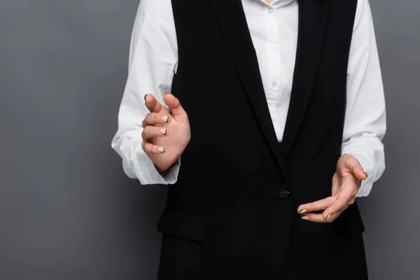 Cropped view of businesswoman pointing with finger at camera on grey background — Stock Photo