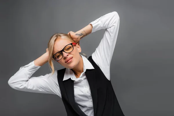 Businesswoman in eyeglasses suffering from headache isolated on grey — Stock Photo