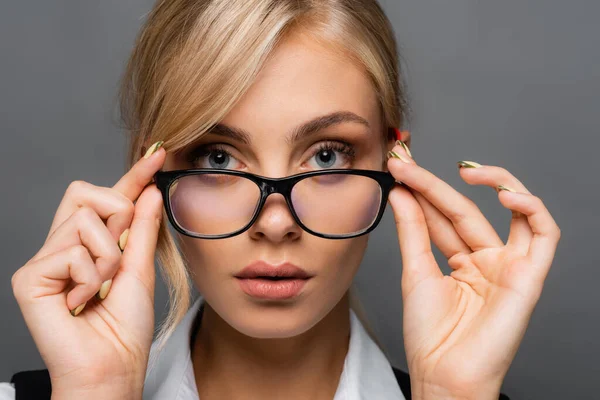 Портрет блондинки-бізнесу, що тримає окуляри ізольовані на сірому — стокове фото