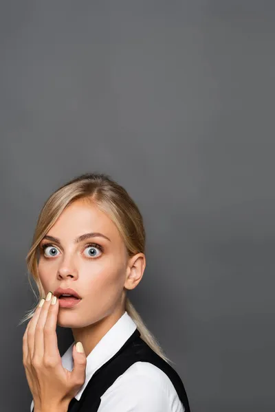 Femme d'affaires choquée en gilet et chemise regardant la caméra isolée sur gris — Photo de stock