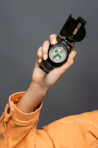 Cropped view of tourist holding compass isolated on grey — Stock Photo