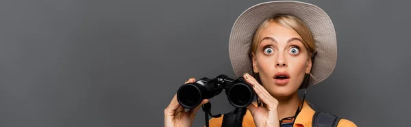 Verblüffter Tourist mit Hut, Fernglas isoliert auf grau, Banner — Stockfoto