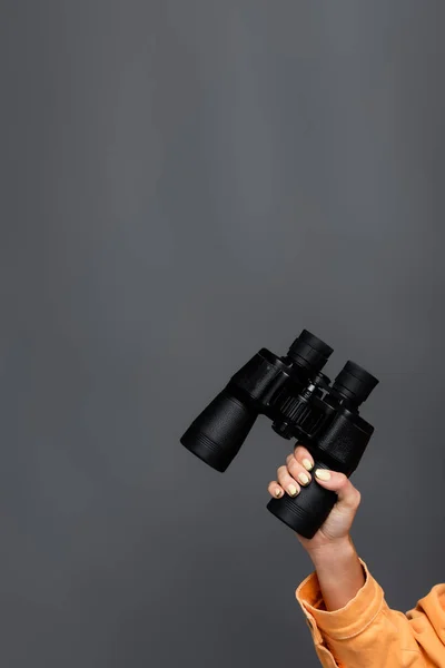 Cropped view of tourist holding binoculars isolated on grey — Stock Photo