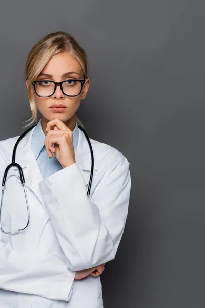 Пасічний лікар у білому пальто та окулярах дивиться на камеру ізольовано на сірому — стокове фото