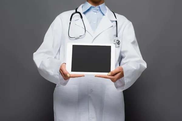 Ausgeschnittene Ansicht des Arztes zeigt digitale Tablette mit leerem Bildschirm isoliert auf grau — Stockfoto