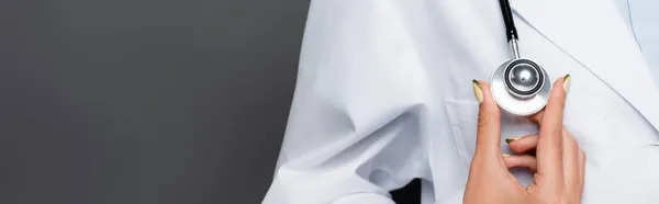 Ausgeschnittene Ansicht des Arztes in weißem Kittel mit Statoskop isoliert auf grau, Banner — Stockfoto