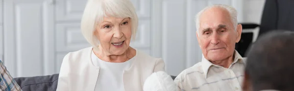 Senior woman holding yard near multiethnic friends in nursing home, banner — Stock Photo