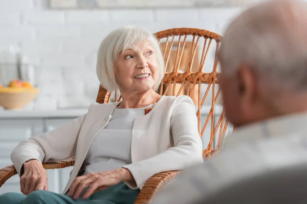 Donna anziana guardando lontano vicino amico offuscata in casa di cura — Foto stock