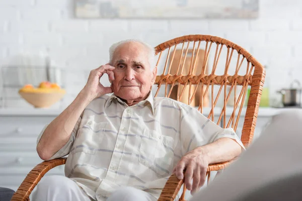 Uomo anziano seduto sulla sedia a dondolo in casa di cura — Foto stock