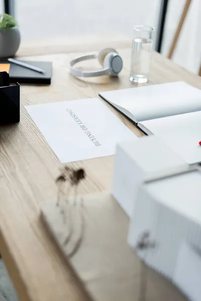 Papel com letras de compra ou locação perto de notebook e vidro de água no escritório — Fotografia de Stock