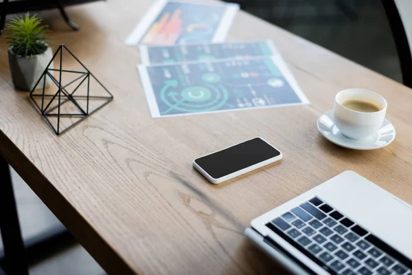 Vista ad alto angolo di dispositivi, caffè e carte sul tavolo in ufficio — Foto stock