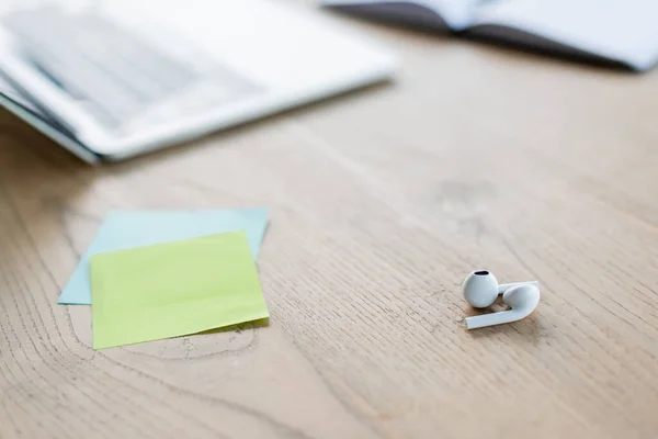 Close up view of earphones near sticky notes in office — Stock Photo
