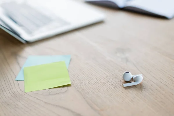 Vista cercana de auriculares cerca de notas adhesivas en la oficina - foto de stock