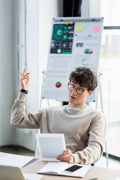 Young transgender person having video call on digital tablet in office — Stock Photo