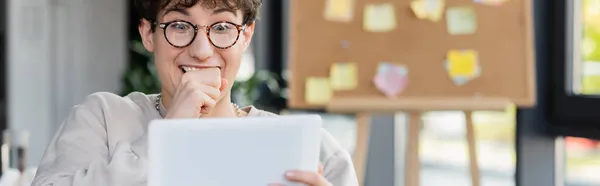 Hombre de negocios sorprendido mirando borrosa tableta digital en la oficina, bandera - foto de stock