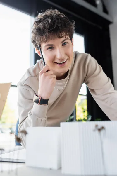 Transgender-Person hält Stift in der Nähe verschwommenes Modell des Gebäudes im Büro — Stockfoto