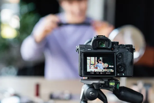 Digital camera near transgender person with cosmetic brush in studio — Stock Photo