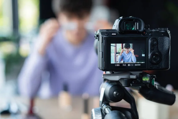 Digital camera near blurred transgender makeup artist with mascara — Stock Photo