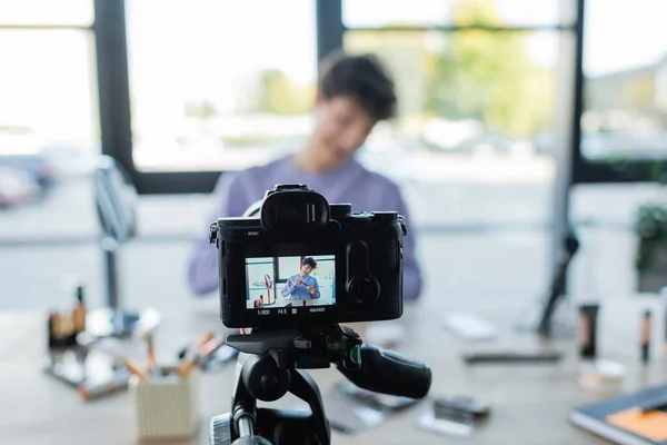 Digital camera near transgender person holding face powder near cosmetics — Stock Photo