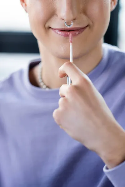 Cropped view of young transgender person holding lip balm — Stock Photo