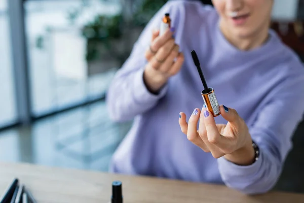 Cropped view of blurred transgender person holding mascara brush — Stock Photo