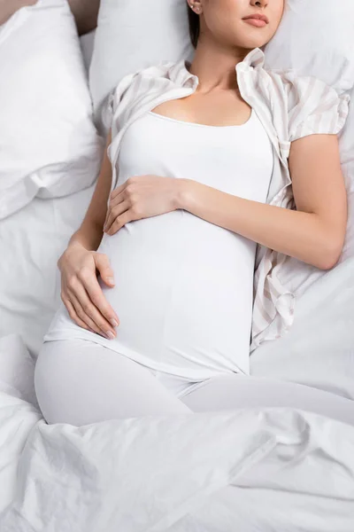 Ausgeschnittener Blick auf Schwangere im Bett — Stockfoto