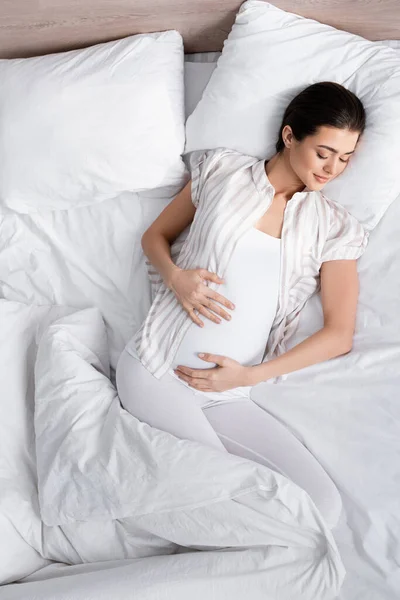 Vista superior da mulher grávida jovem e satisfeito na cama — Fotografia de Stock