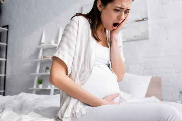 Joven embarazada que sufre de calambres - foto de stock