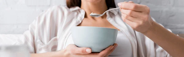 Vista recortada de la mujer joven comiendo avena, pancarta - foto de stock