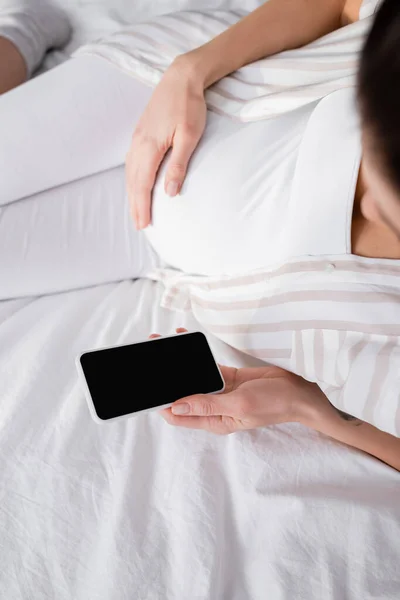 Top view of pregnant woman holding smartphone with blank screen — Stock Photo