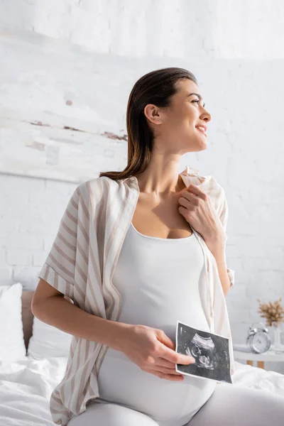 Cheerful pregnant woman holding ultrasound scan — Stock Photo