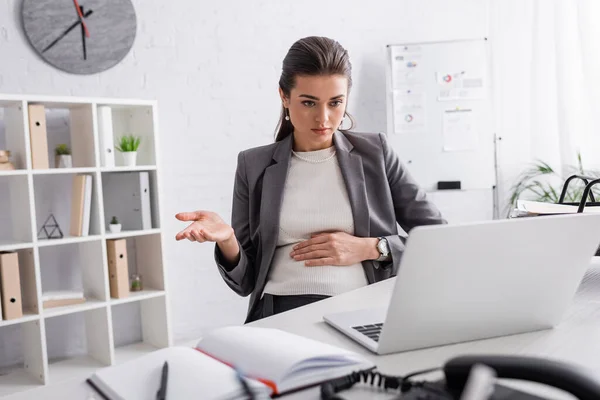 Junge schwangere Geschäftsfrau gestikuliert bei Videoanruf — Stockfoto