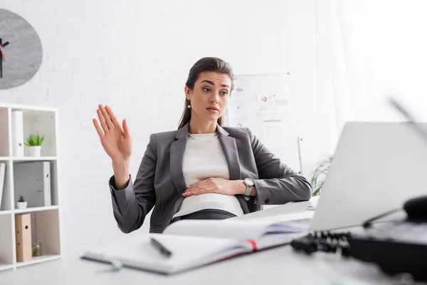 Gesticolare donna d'affari incinta durante la videochiamata sul computer portatile — Foto stock