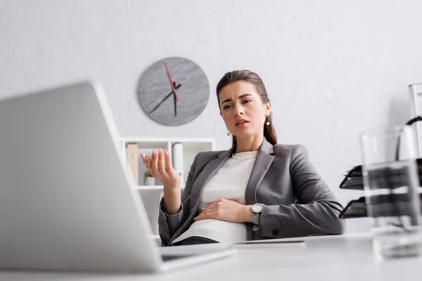 Displeased pregnant businesswoman gesturing during video call on laptop — Stock Photo